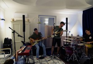Tom Cridland  under a Nord Stage keyboard, Andy Baker on bass, Justin Woodward on guitar, and Harry Michael on drums. as they practice at a villa in Capri, Italy.