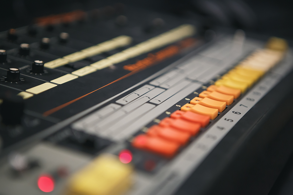 Blurred photo of Roland TR-808 drum machine licensed from Adobe Stock.